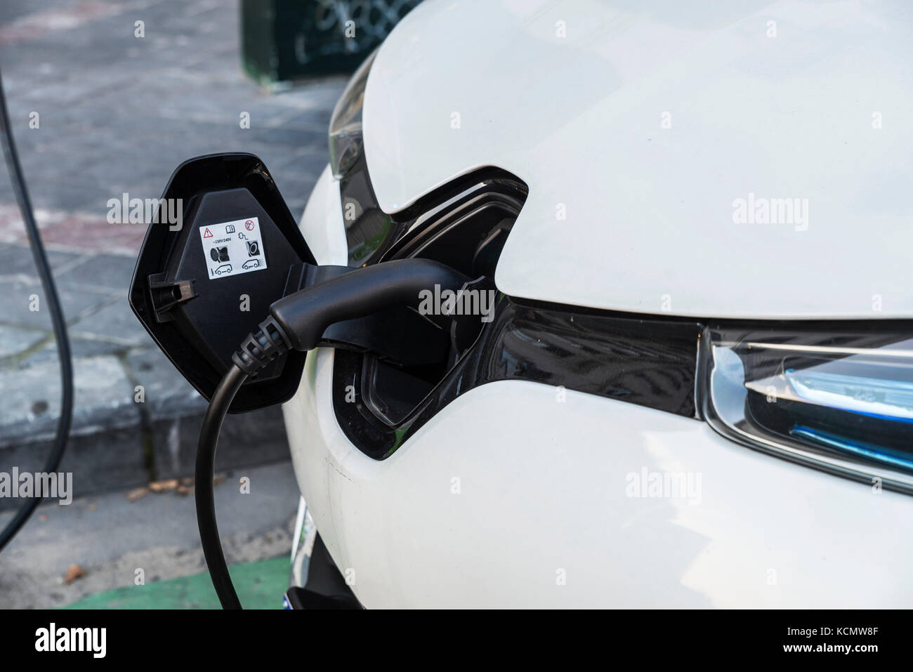 Electric car recharging batteries at a recharge point on a street in
