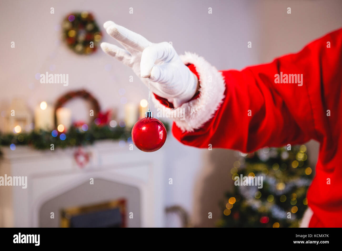 Mid-section of santa claus holding a bauble Stock Photo