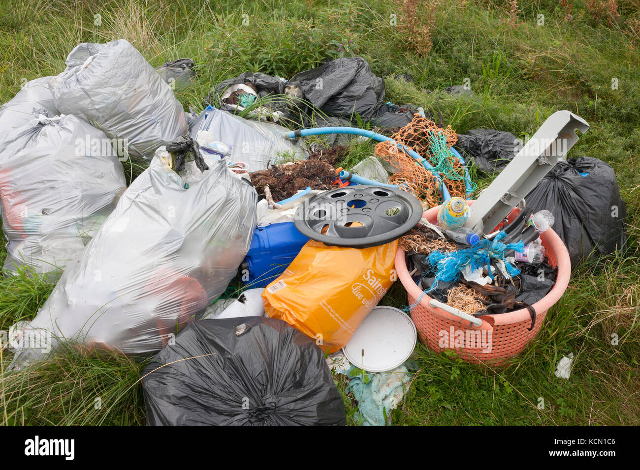 A pile of assorted plastic materials await removal from the coastal landscape, having been collected by volunteers from a beach on Holy Island, on 27th September 2017, on Lindisfarne Island, Northumberland, England. The amount of rubbish found dumped on UK beaches rose by a third last year, according to a new report. More than 8,000 plastic bottles were collected by the Marine Conservation Society’s annual beach clean-up at seaside locations from Orkney to the Channel Islands on one weekend in September 2016. The Holy Island of Lindisfarne, also known simply as Holy Island, is an island off th Stock Photo