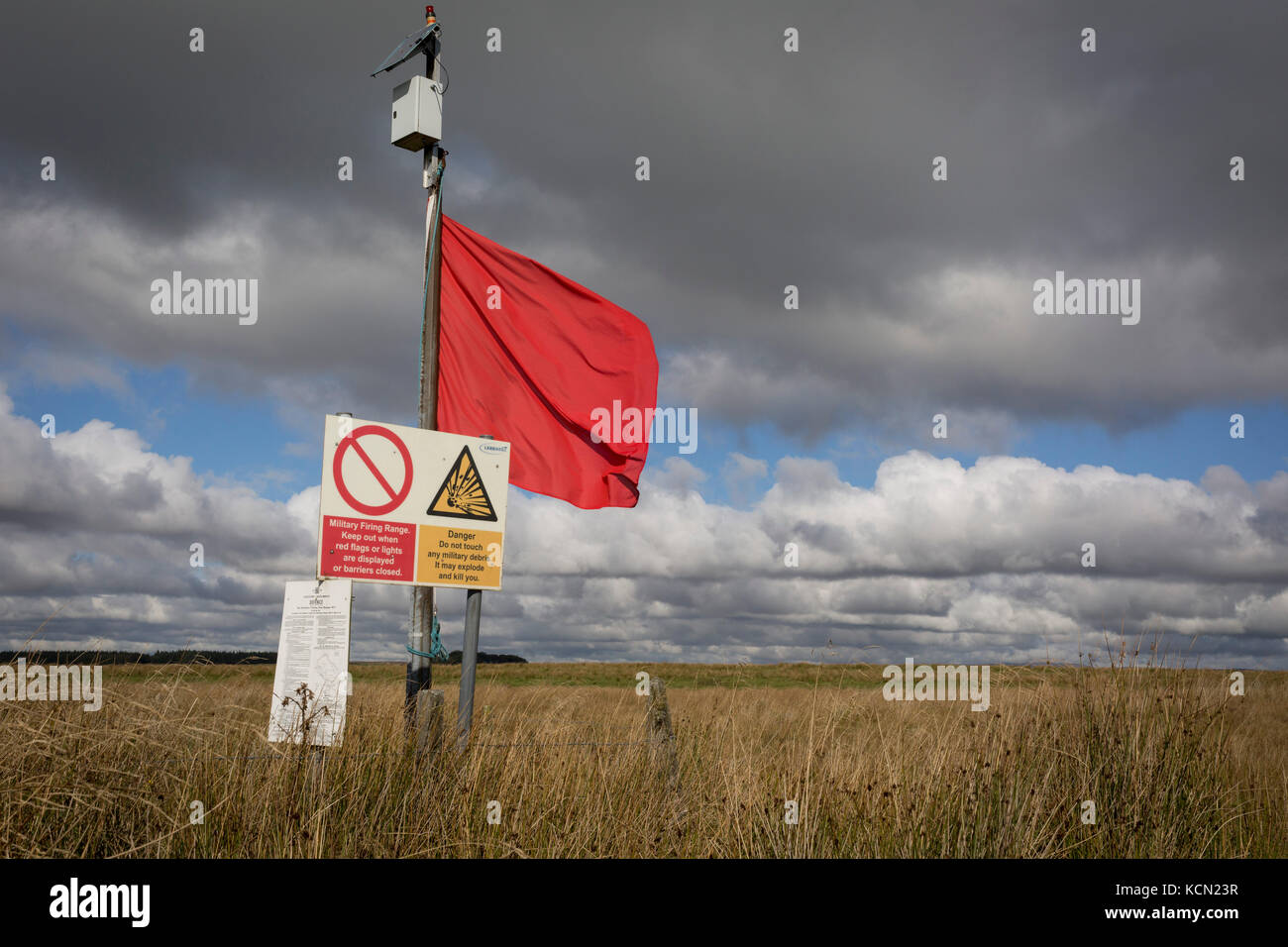 A red warning flag flies on the perimeter during military live firing at Otterburn Ranges, on 28th September 2017, in Otterburn, Northumberland, England. Twenty-three per cent of Northumberland National Park is owned by the Ministry of Defence and used as a military training area though they encourage as much access to the area as possible. Sometimes areas are cordoned off from the public for military exercises. Visitors are welcome outside of live firing times if no red flags are displayed. When military exercises are happening, red flags around the boundaries indicate restricted access. Visi Stock Photo