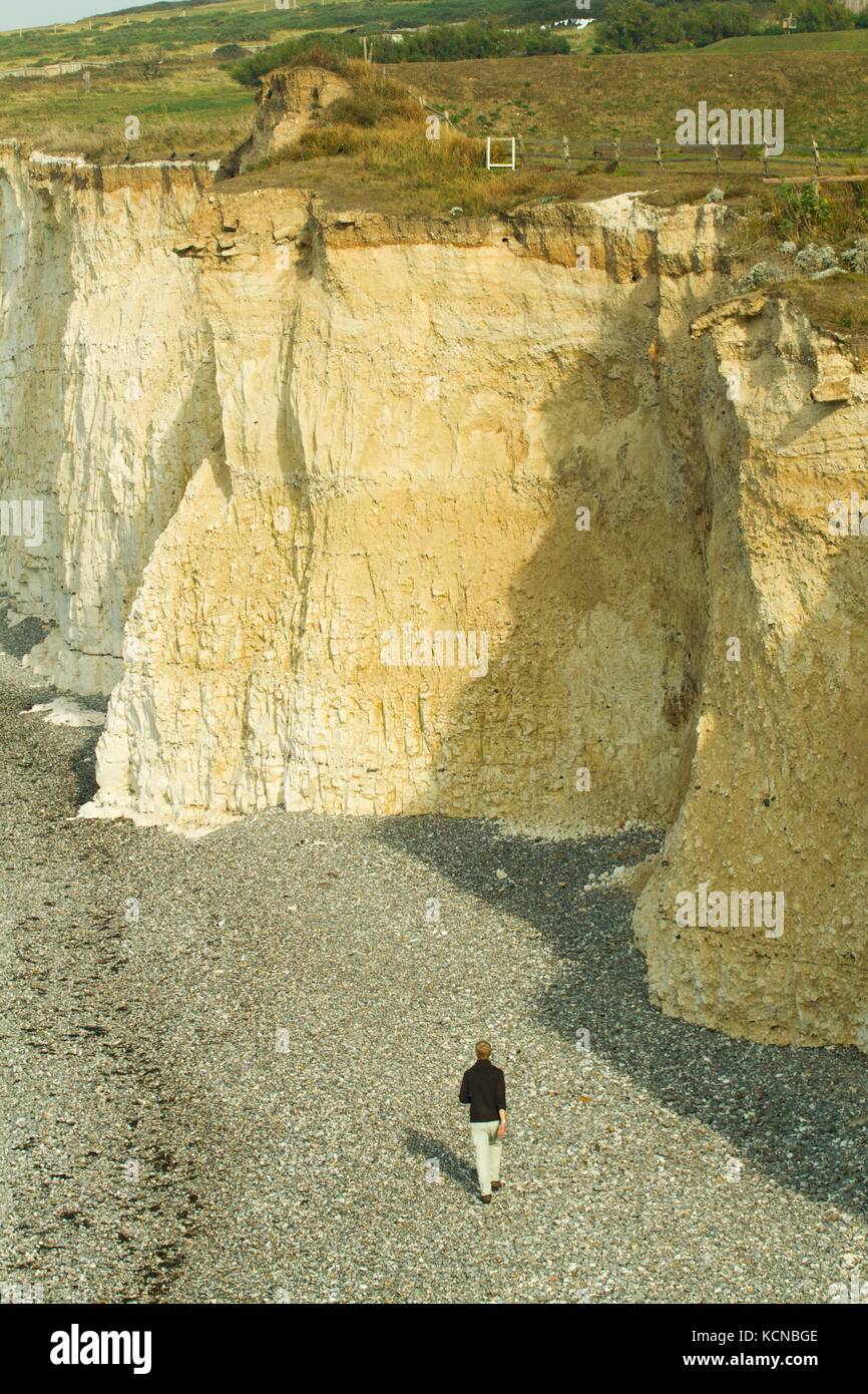 Person photographing chalk cliffs near Beachy Head for scale. Cliffs formed in the