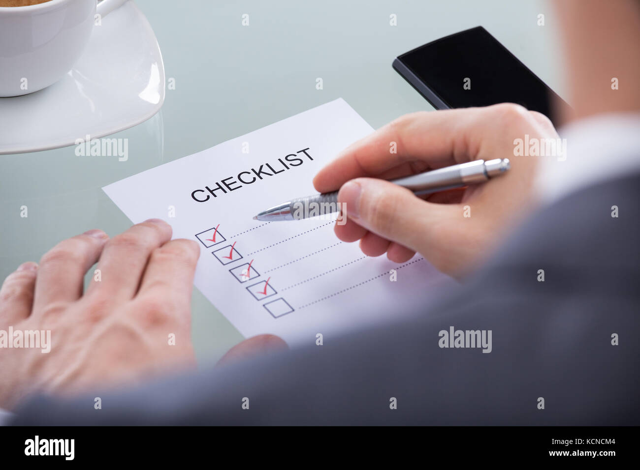 Close-up Of Businessperson Hand With Pen Marking A Check Box Stock Photo
