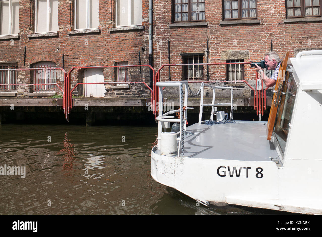 tour boat, Ghent Belgium ,photographer on deck, zoom lens, Stock Photo
