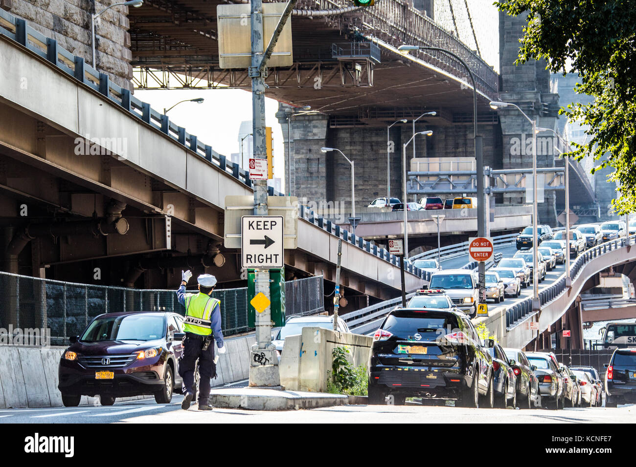 Traffic policeman directing cars entering Manhattan on the Brooklyn Bridge, New York City, USA Stock Photo