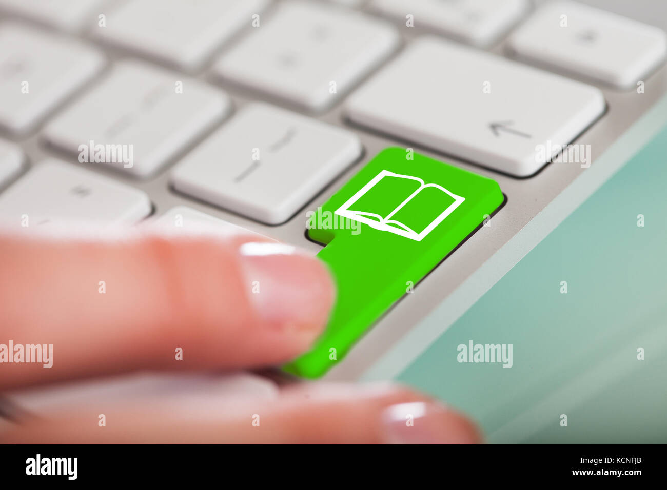 Close-up Of Hand Over Green Key With Book Icon Stock Photo
