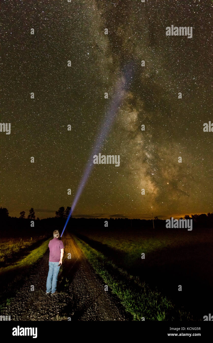 Man shines a flashlight toward the Milky Way on Manitoulin Island, Ontario, Canada Stock Photo