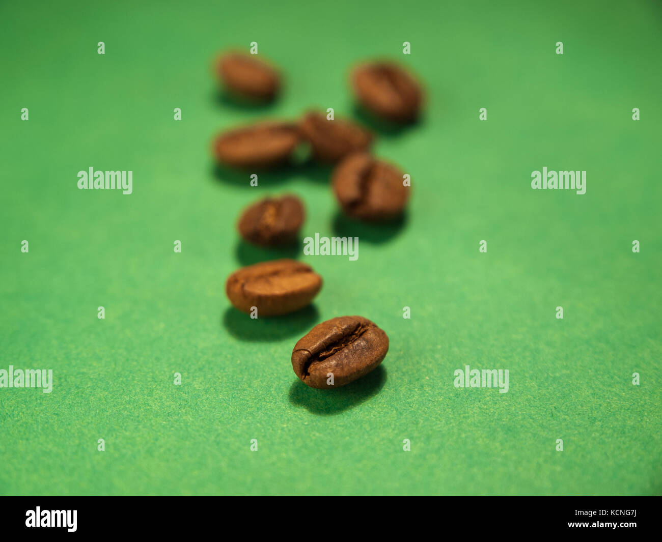 Roasted coffee beans isolated on green background Stock Photo