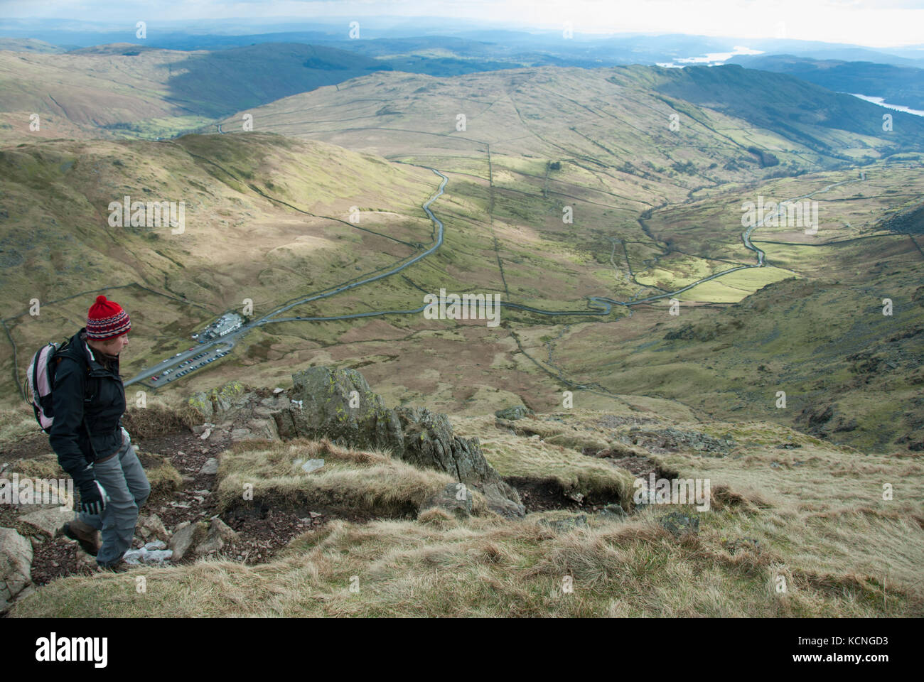 Hiker on descent to Kirstone Inn and Kirkstone Pass from Red Screes, near Ambleside, Lake District, UK Stock Photo