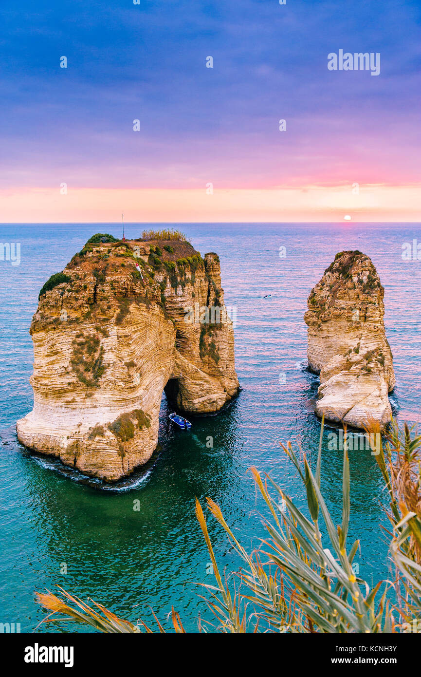 Beautiful sunset on Raouche, Pigeons' Rock. In Beirut, Lebanon.Sun and Stones are reflected in water.dense clouds in the sky. Stock Photo