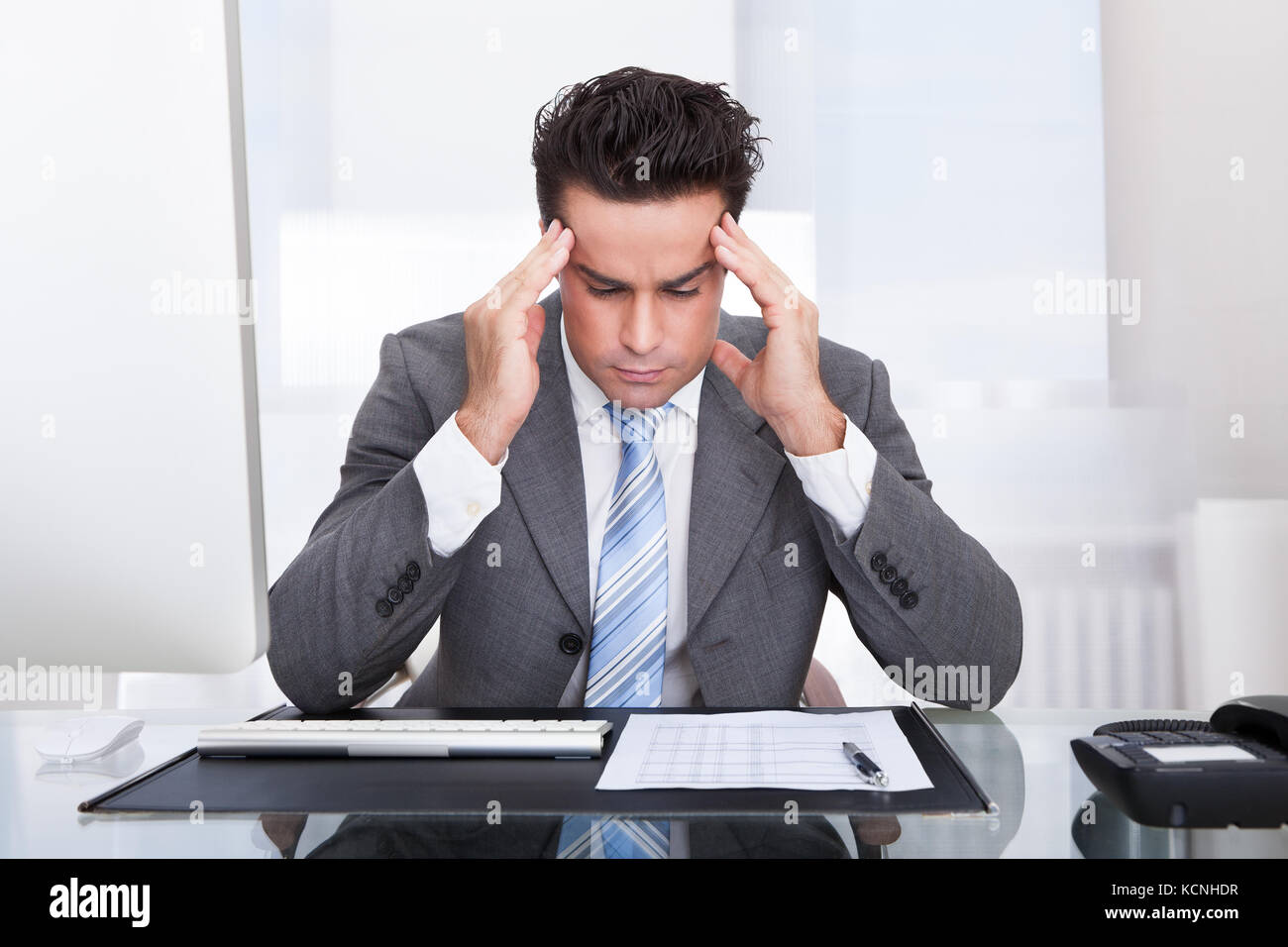 Portrait Of A Stressed Businessman Sitting At Desk Stock Photo