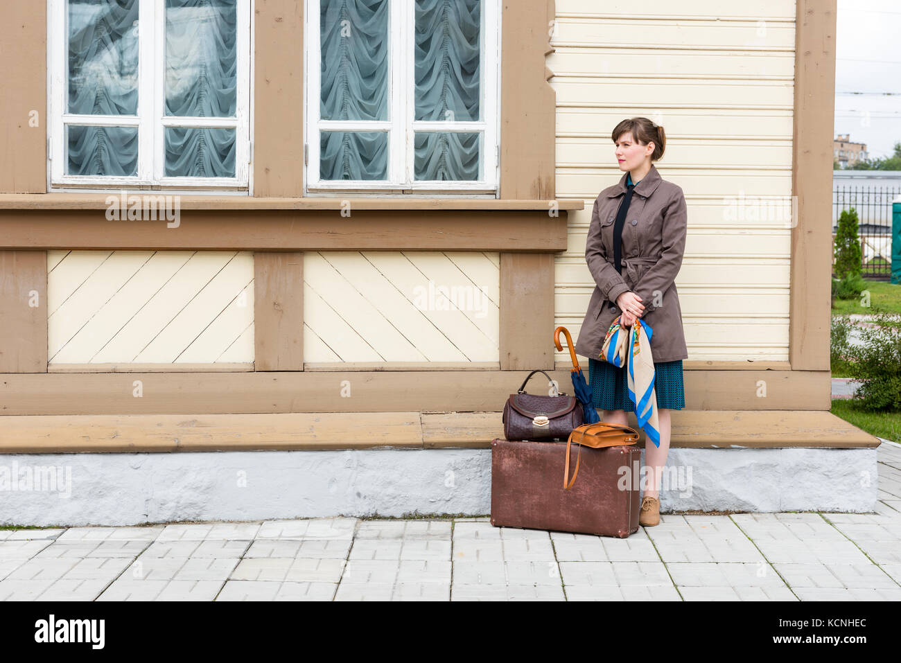 young woman waiting for the arrival of a train at a small station in retro style Stock Photo