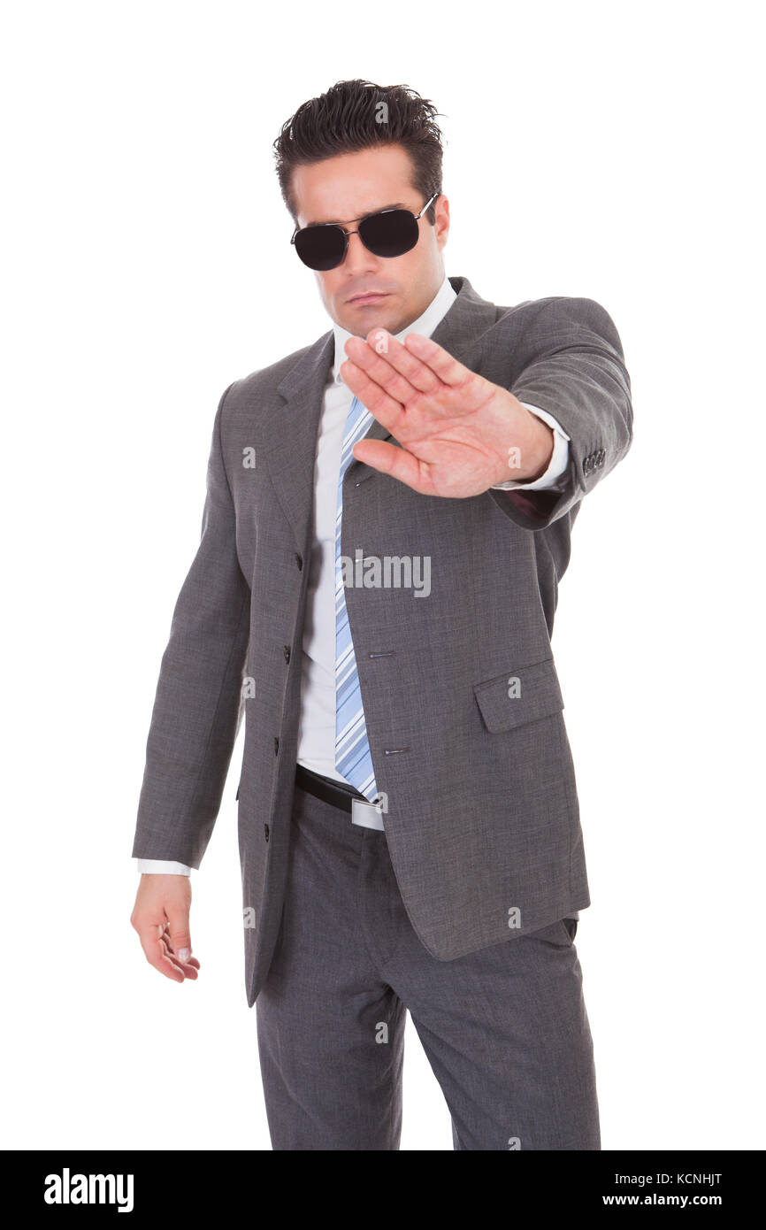 Portrait Of Young Businessman Wearing Sunglasses Gesturing Stop Sign Stock Photo