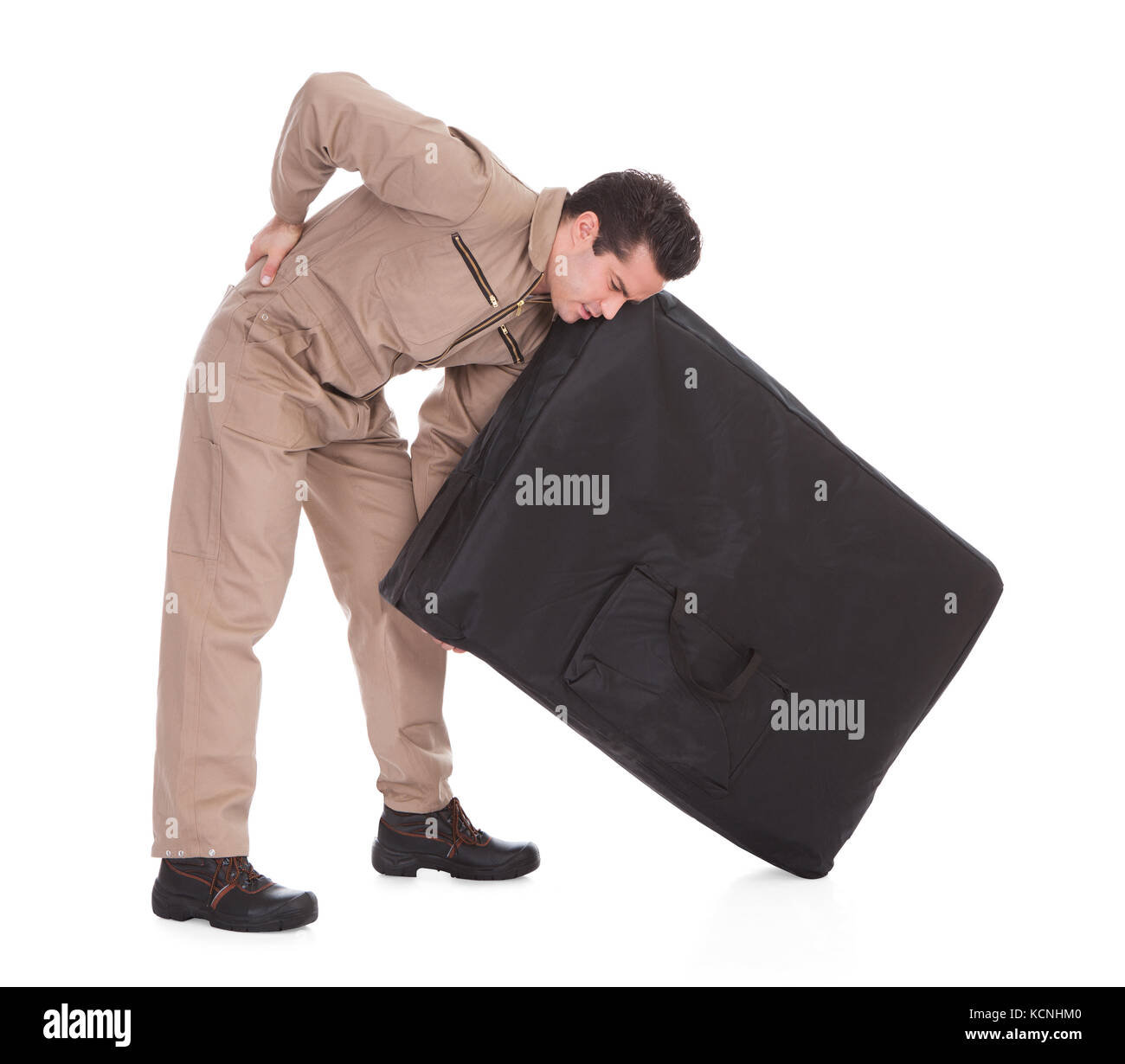 Young Man Suffering From Back Pain Lifting Luggage Over White Background Stock Photo