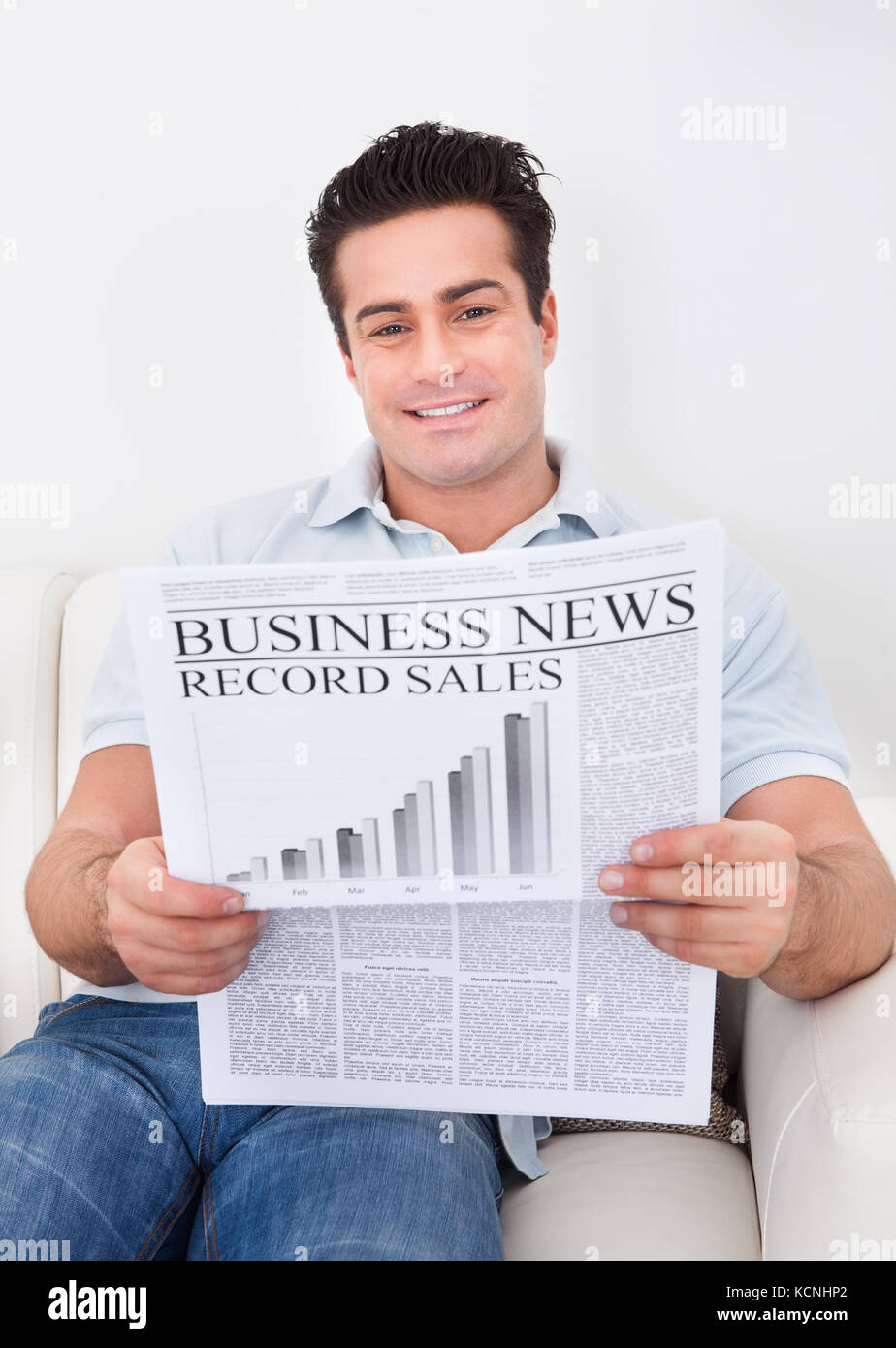 Portrait Of Happy Man Holding Business Newspaper Stock Photo