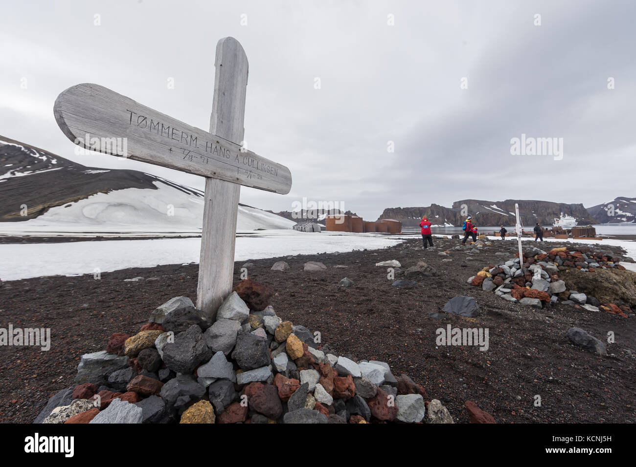 A lonely grave marker juts up into a featureless sky at Whalers Bay on Deception Island.  South Shetland Island Stock Photo