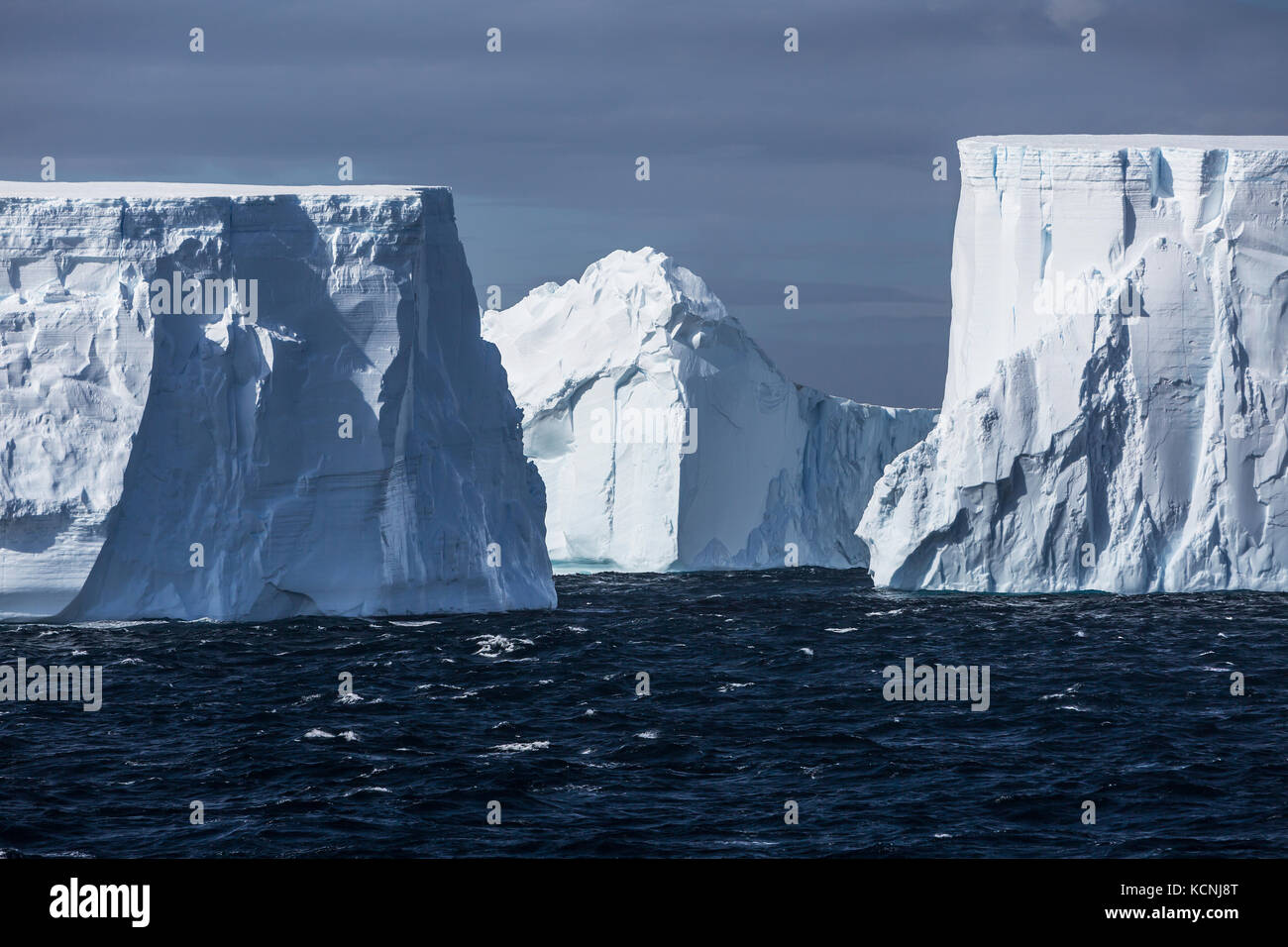 Large tabular icebergs slowly float by on the wind swept waters of Antarctic Sound, Antarctic Peninsula Stock Photo