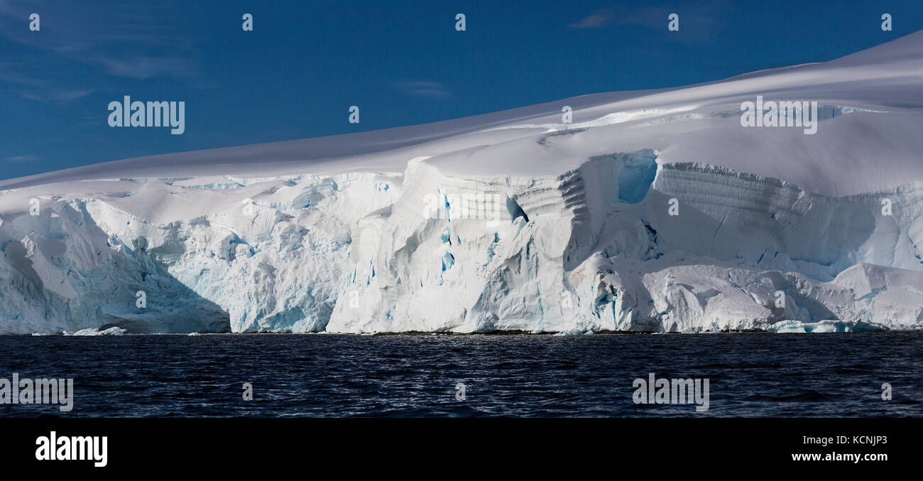 Heavily glaciated ice reaches out to waiting water in Wilhelmina Bay, Gerlache Strait, Antarctic Peninsula Stock Photo