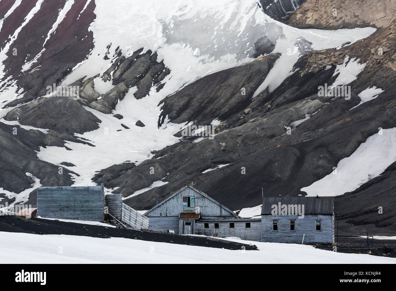 Abandoned buildings slowly deteriate amongst a bleak landscape on Deception Island.  South Shetland Islands, Antarctic Peninsula. Stock Photo