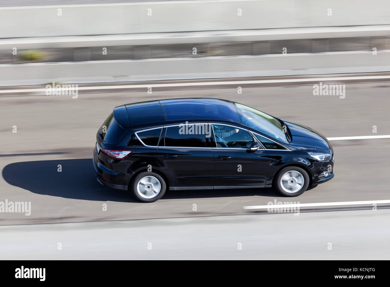 Black minivan driving fast on the highway Stock Photo