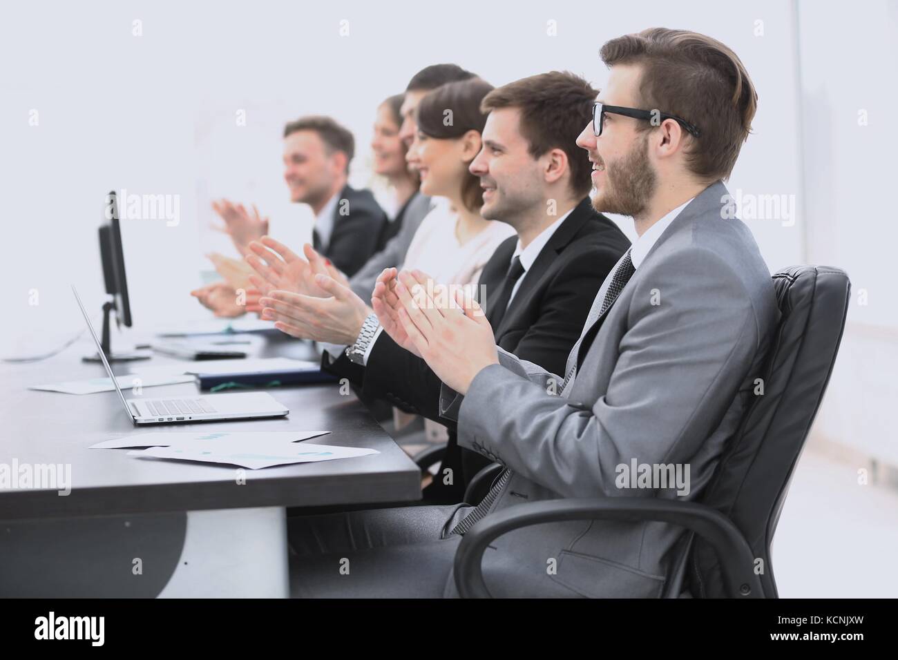 cheering business team sitting at Desk Stock Photo - Alamy