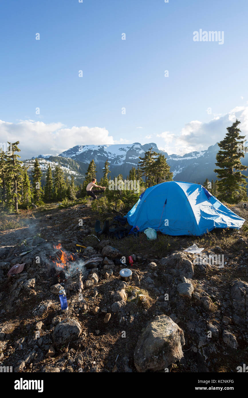 A hiker stretches while camping on Lee Plateau, on Vancouver Island, British Columbia, Canada Stock Photo