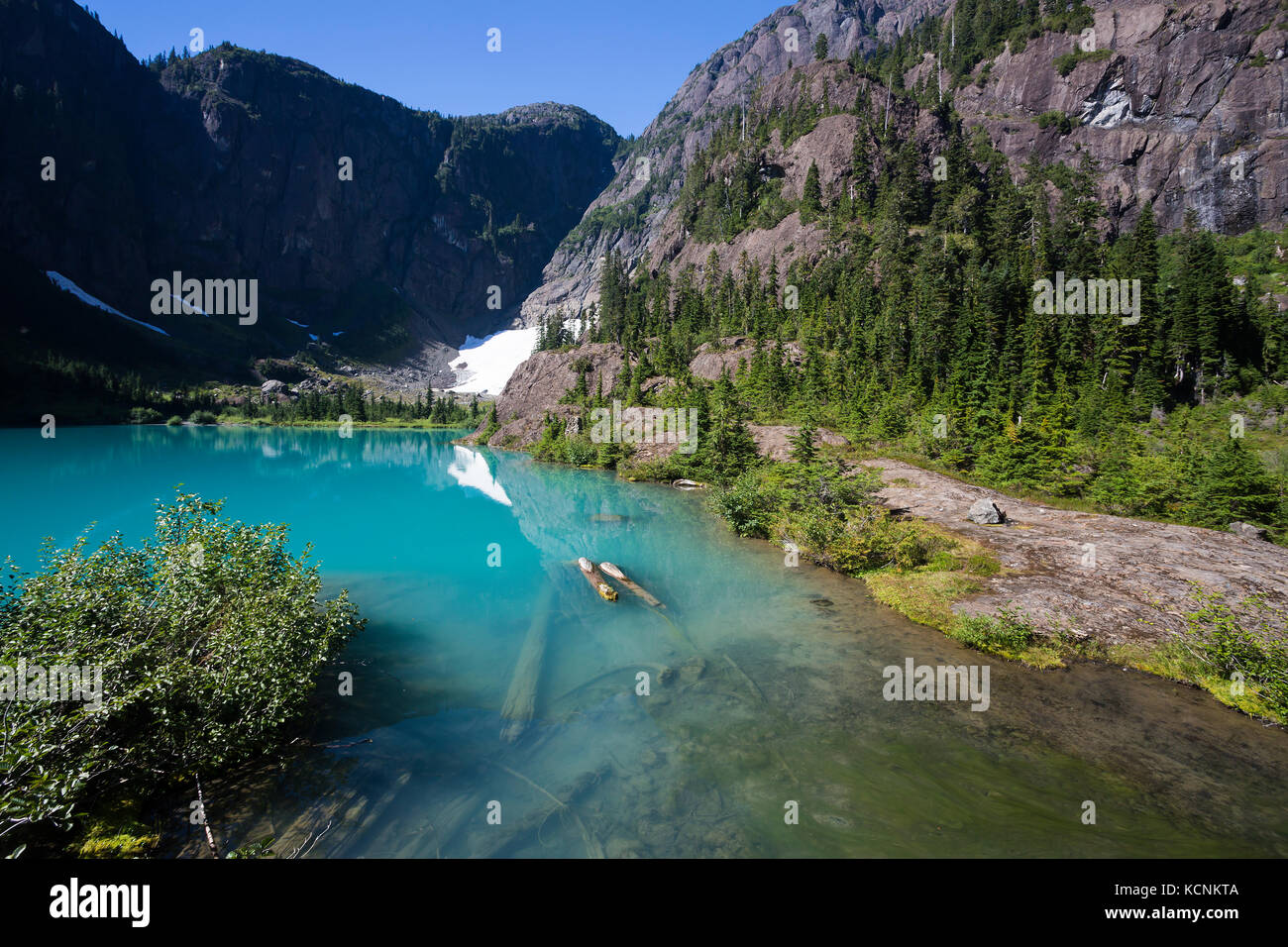 The beautiful turquoise water of Century Sam lake mirrors a mountian