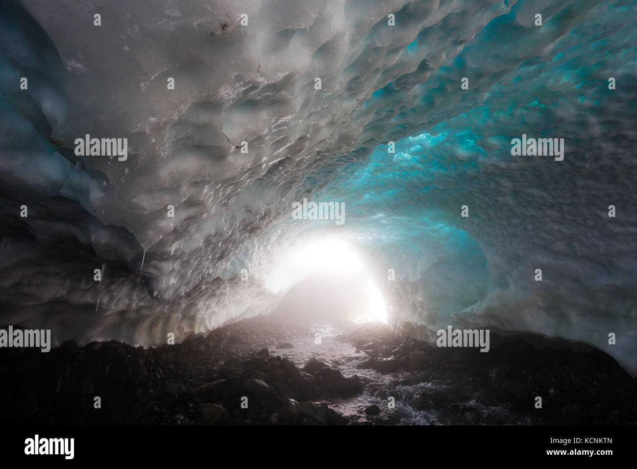 Ice water drips from the roof of a snow cave at the base of Century Sam lake, Strathcona Park, Vancouver Island, British Columbia, Canada Stock Photo