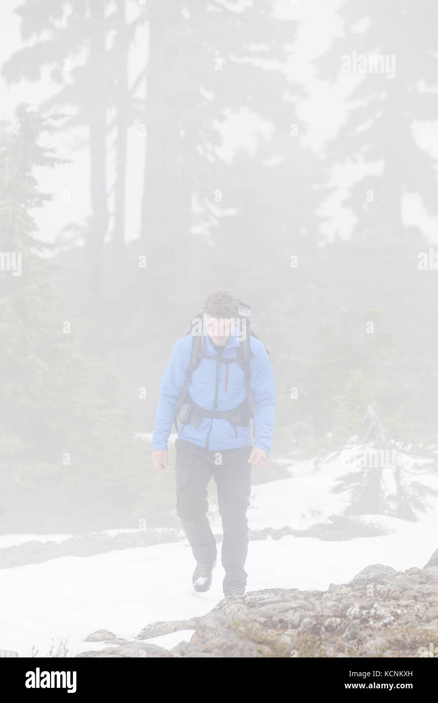 A hiker walks through an inversion while making his way up to Lee Plateau on Vancouver Island, British Columbia, Canada Stock Photo