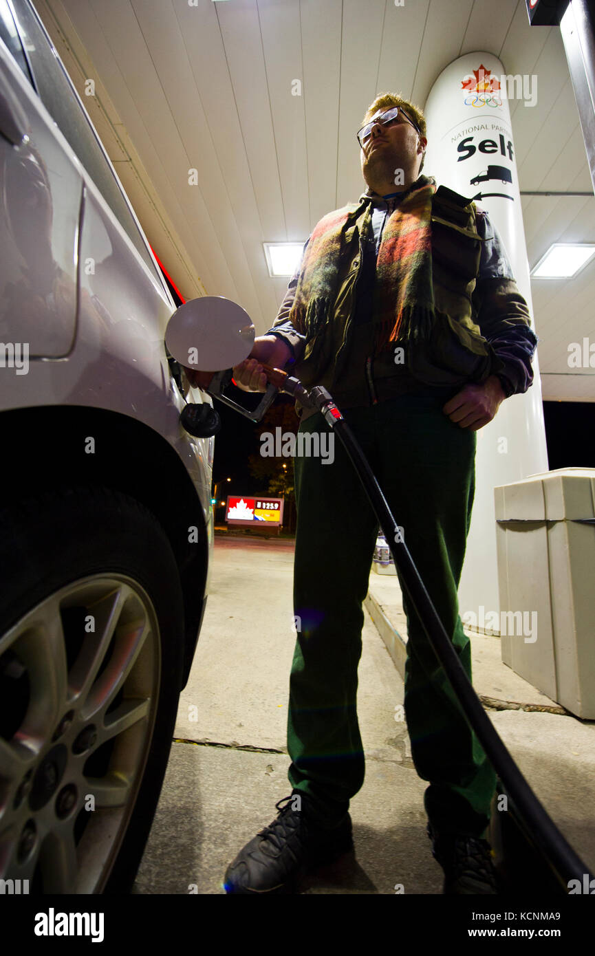 young man filling in the car tank at a gas station Stock Photo - Alamy