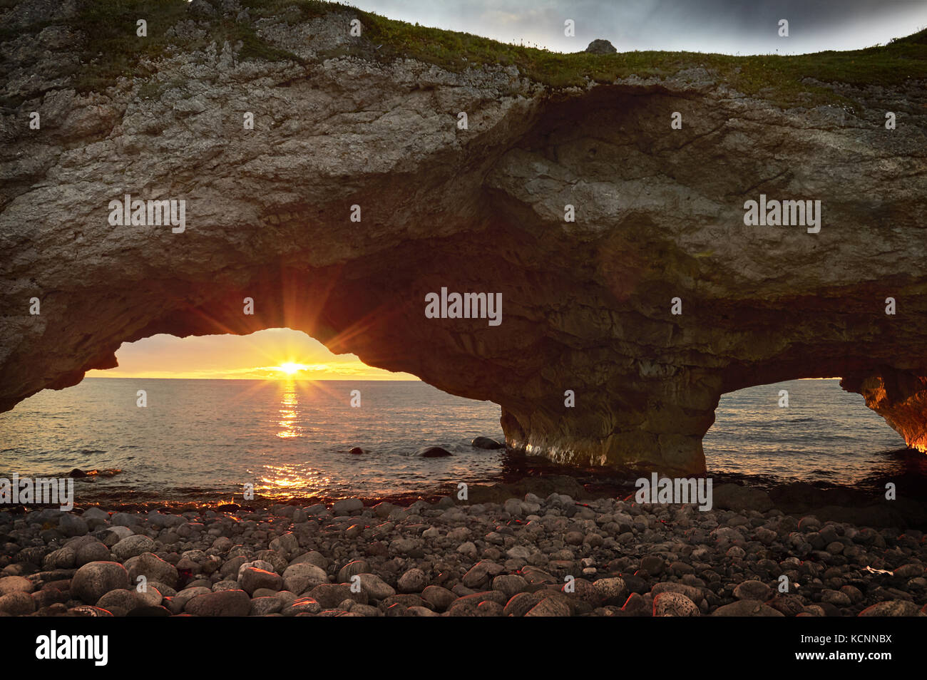 Sunset Through the Arches, Lime Stone rock formation, the Arches Provincial Park, Great Northern Penenusla, Newfoundland & Labrador Stock Photo