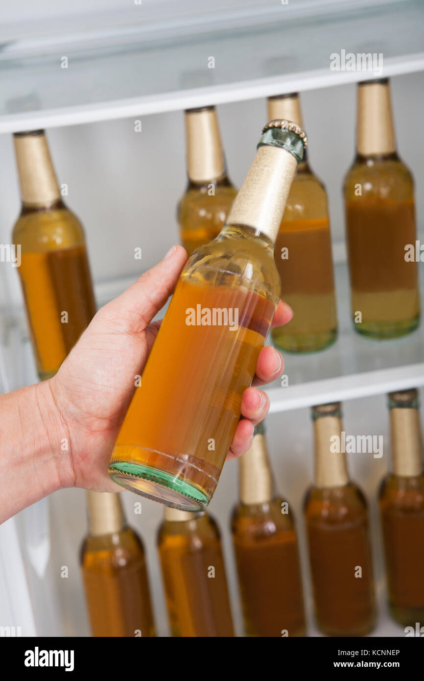 Man choosing bottle of beer from a refrigerator Stock Photo