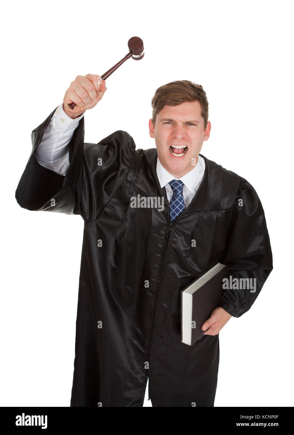 Young Frustrated Male Judge Holding The Gavel And Book Over White Background Stock Photo