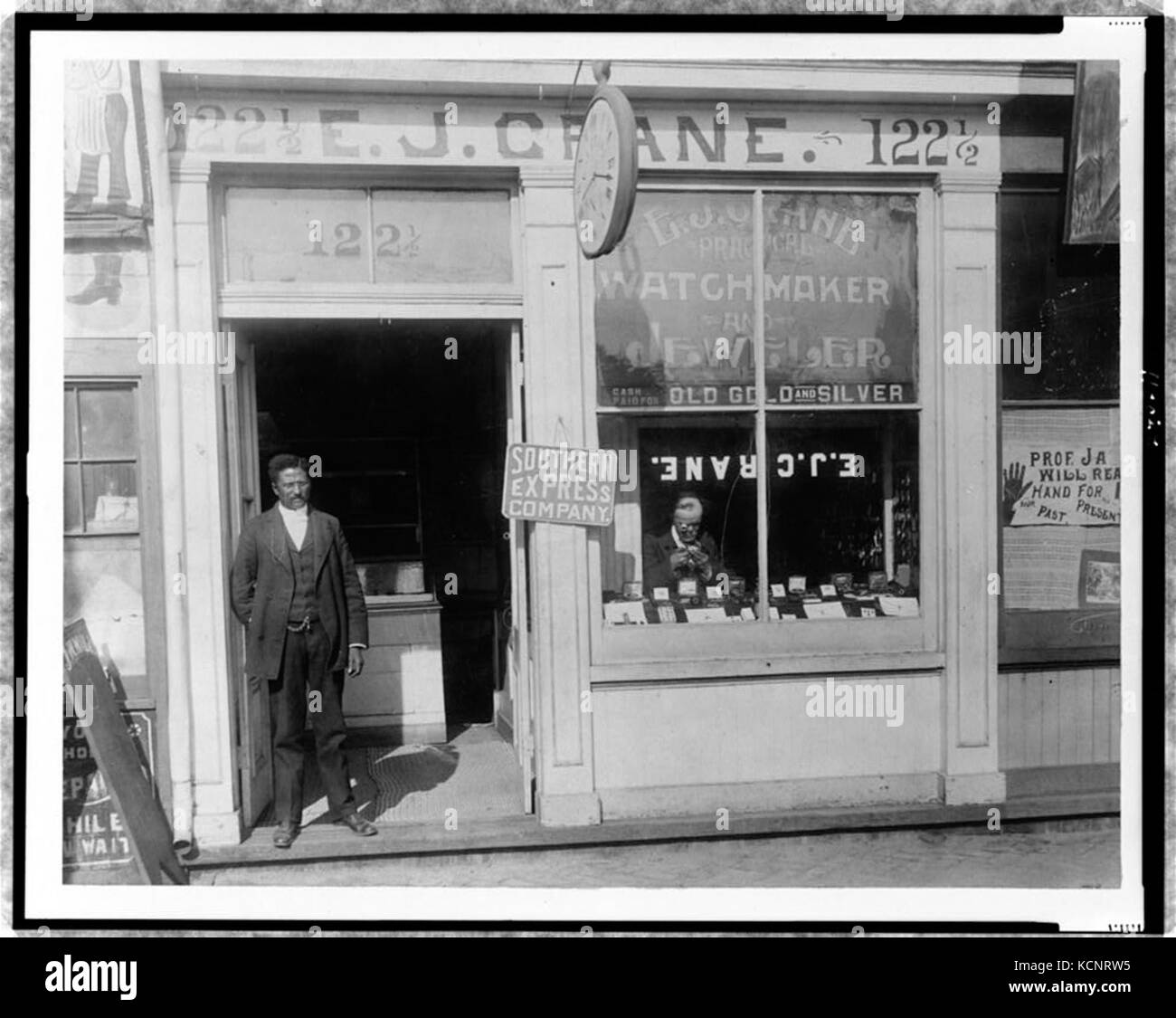 E.J. Crane, watchmaker and jewelry store with man working in window and
