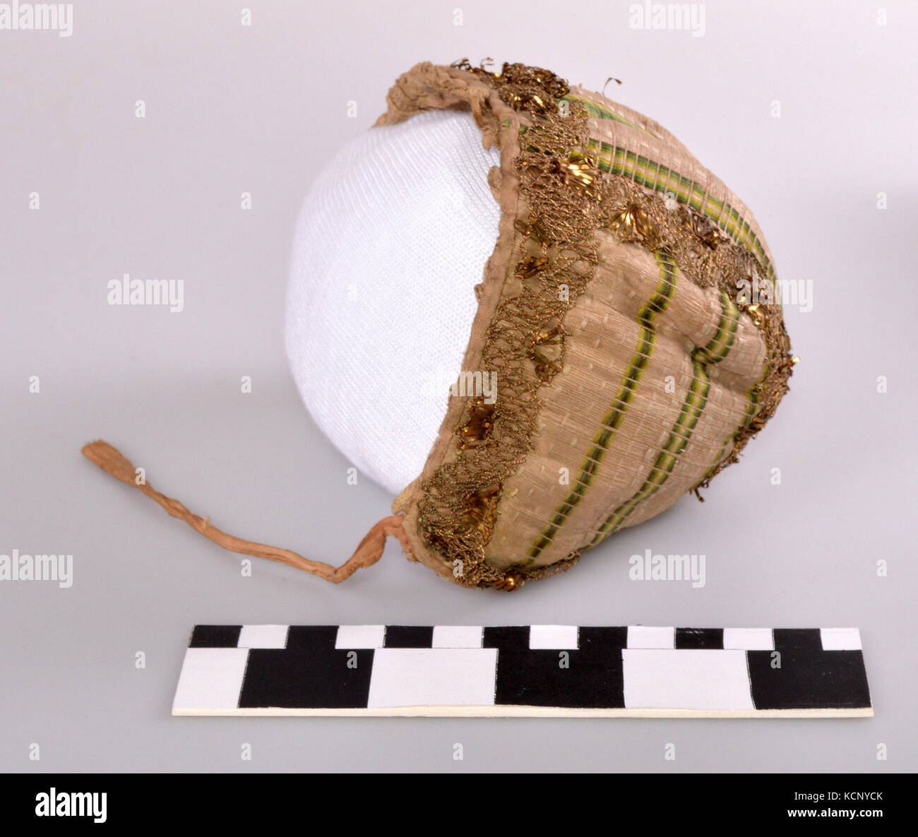 This refers to an infant cap featuring a green striped design, a ...