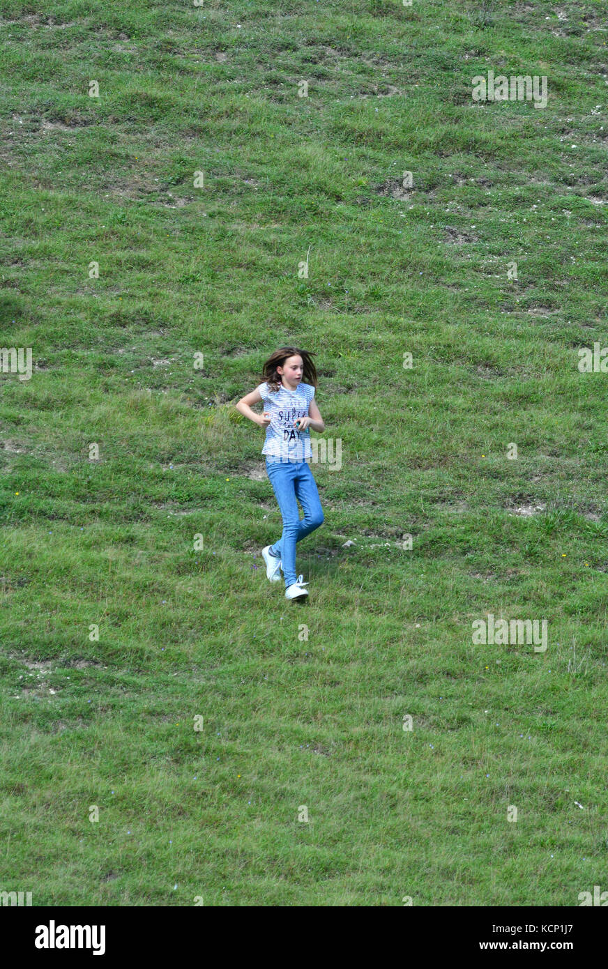 Young Girl running down a hill at Barton Hills Nature Reserve in