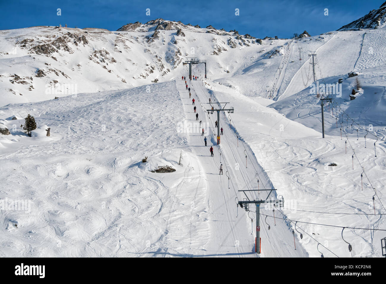 Ski resort in the Swiss Alps. Skiers ascend on rope tow up Stock Photo