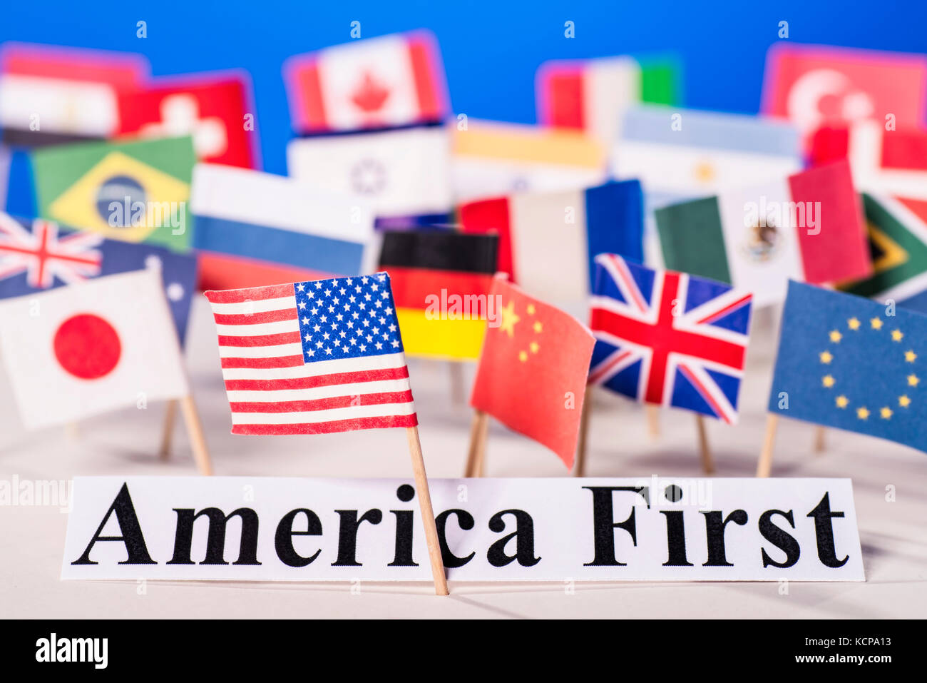 American flag is in front of the slogan America First and many flags of other countries. Stock Photo