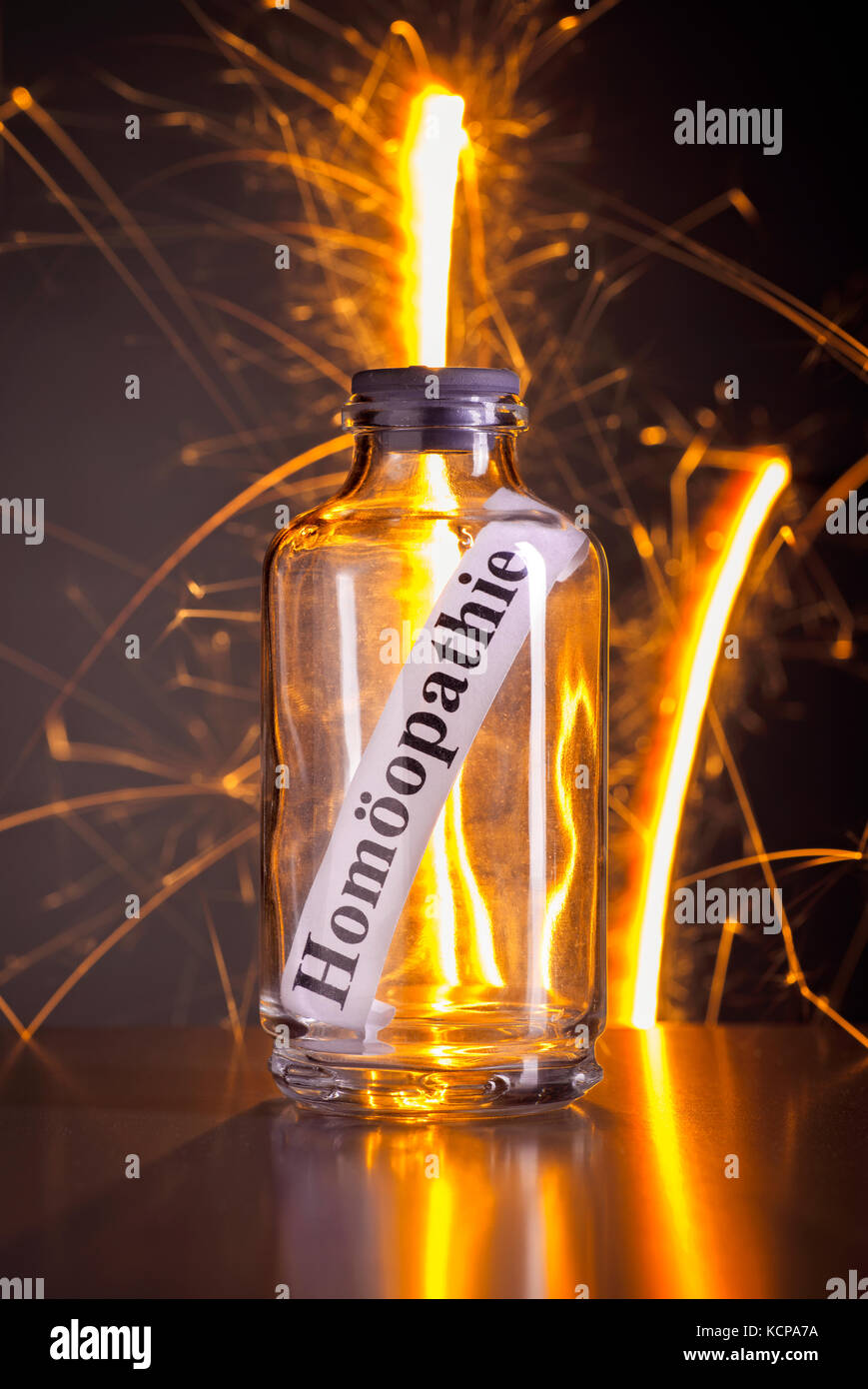 Glass with the word homeopathy and stray sparks Stock Photo