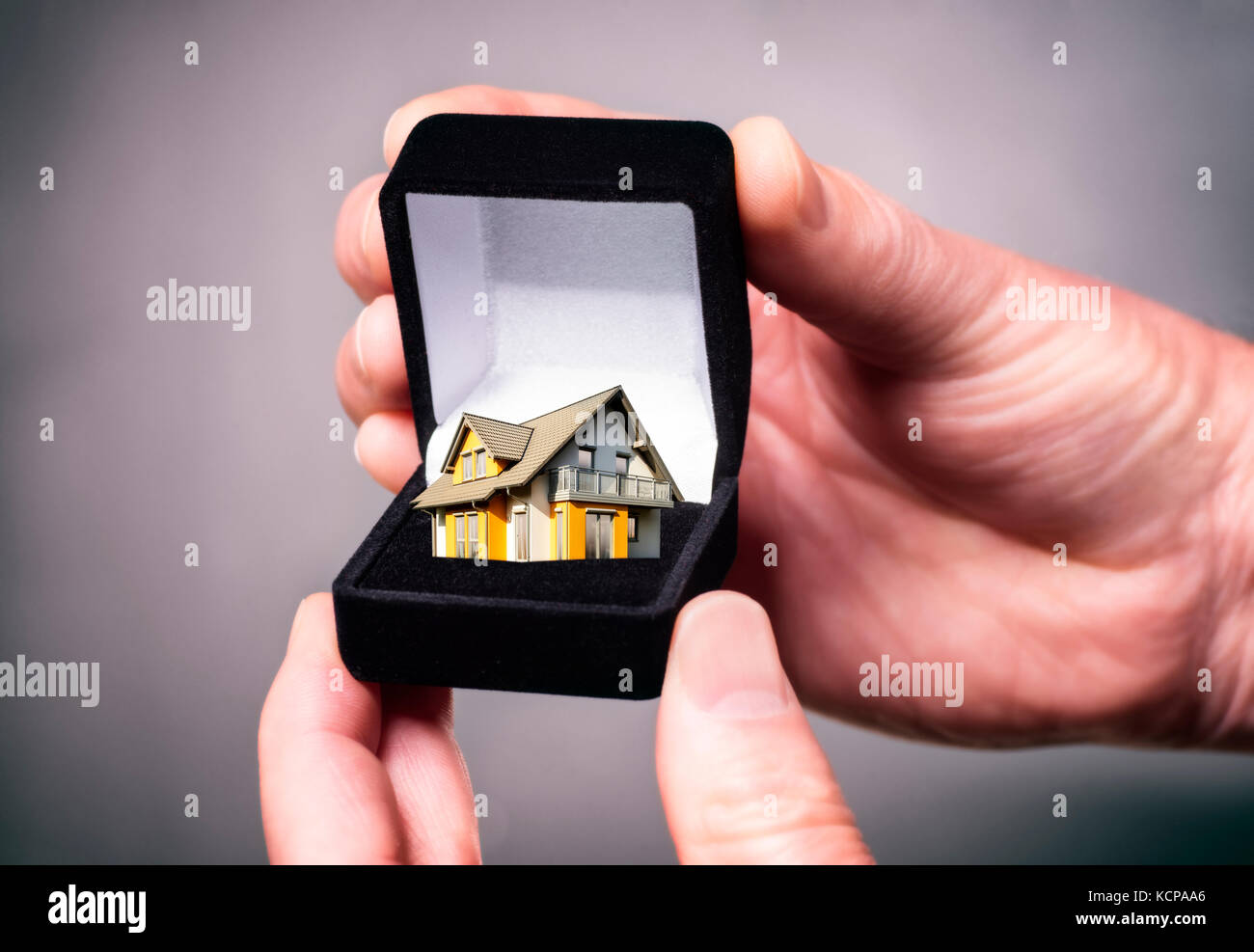 Hand holding jewellery box with house Stock Photo