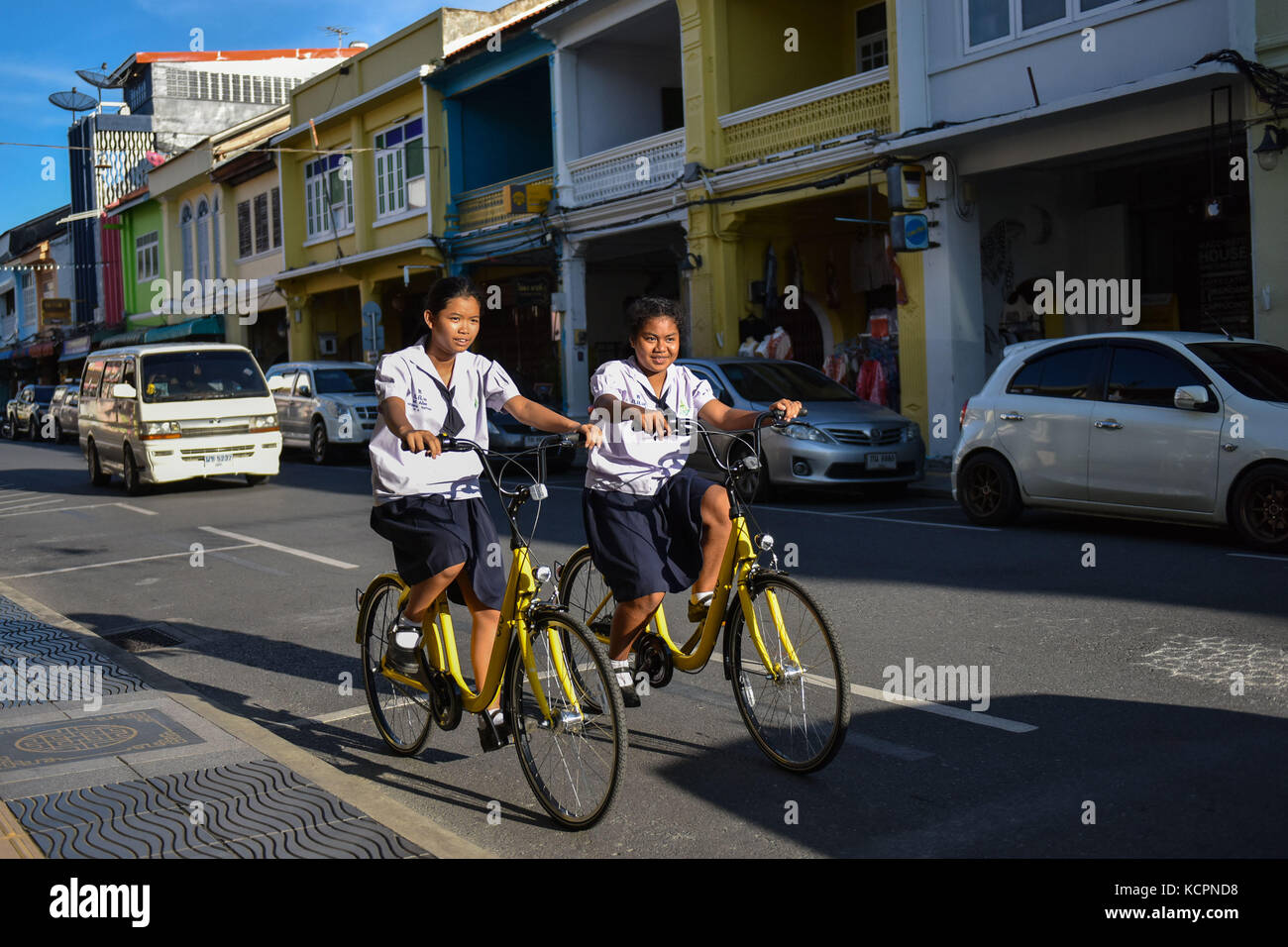 Phuket, Thailand. 5th Oct, 2017. Local students ride ofo sharing-bikes at a commercial area in Phuket, Thailand, Oct. 5, 2017. China's dock-less bike-sharing company ofo provided more than 1,000 bikes in Phuket's key locations in late September and offered a 1-month free trial without deposit fee. Now the bike-sharing service has benefited local residents and tourists. Ofo's regular service fee will be charged at 5 Baht per 30 minutes usage, with a deposit fee of 99 Baht. Credit: Li Mangmang/Xinhua/Alamy Live News Stock Photo