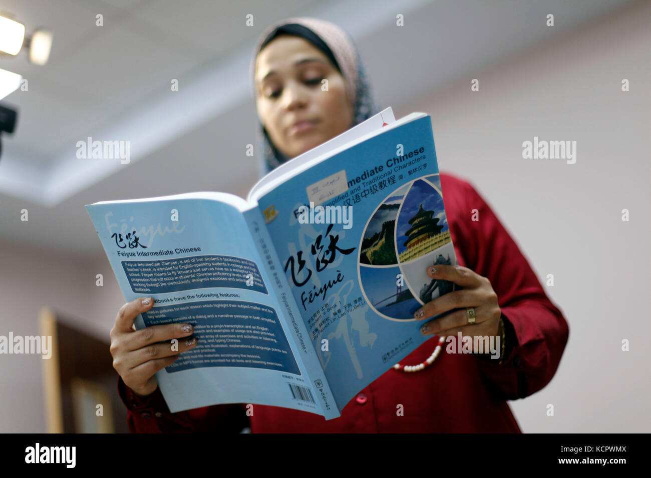 (171006) -- CAIRO, Oct. 6, 2017 (Xinhua) -- Rasha Kamal reads a Chinese textbook in her office at the Ain Shams University in Cairo, Egypt, on Sept. 28, 2017. Recommended by their brother Abdullah Kamal, a famous Egyptian journalist who foresaw the rise of China as a global power, twin sisters Rasha and Shiamaa Kamal decided to study the Chinese language in the 1990s only for better understanding the mighty economic force. Now, they have become the building blocks of a bridge that connects the cultures of China and the Arab world, working as established translators and lecturers in the Chinese Stock Photo