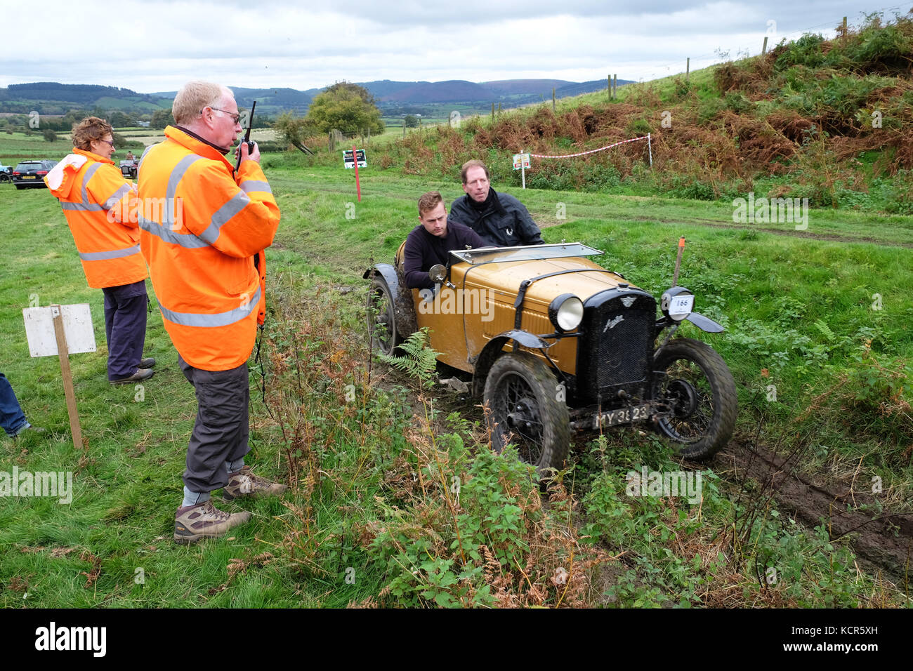Badlands Farm near Kinnerton, Powys - October 2017 - Vintage Sports Car Club ( VSCC ) Welsh Trial a hill climb event where competitors score points as they progress up a muddy hill climb - Shown here a vintage Austin 7 built in 1930 crossing the start line under the gaze of the competition marshalls on the hill climb. Credit: Steven May/Alamy Live News Stock Photo