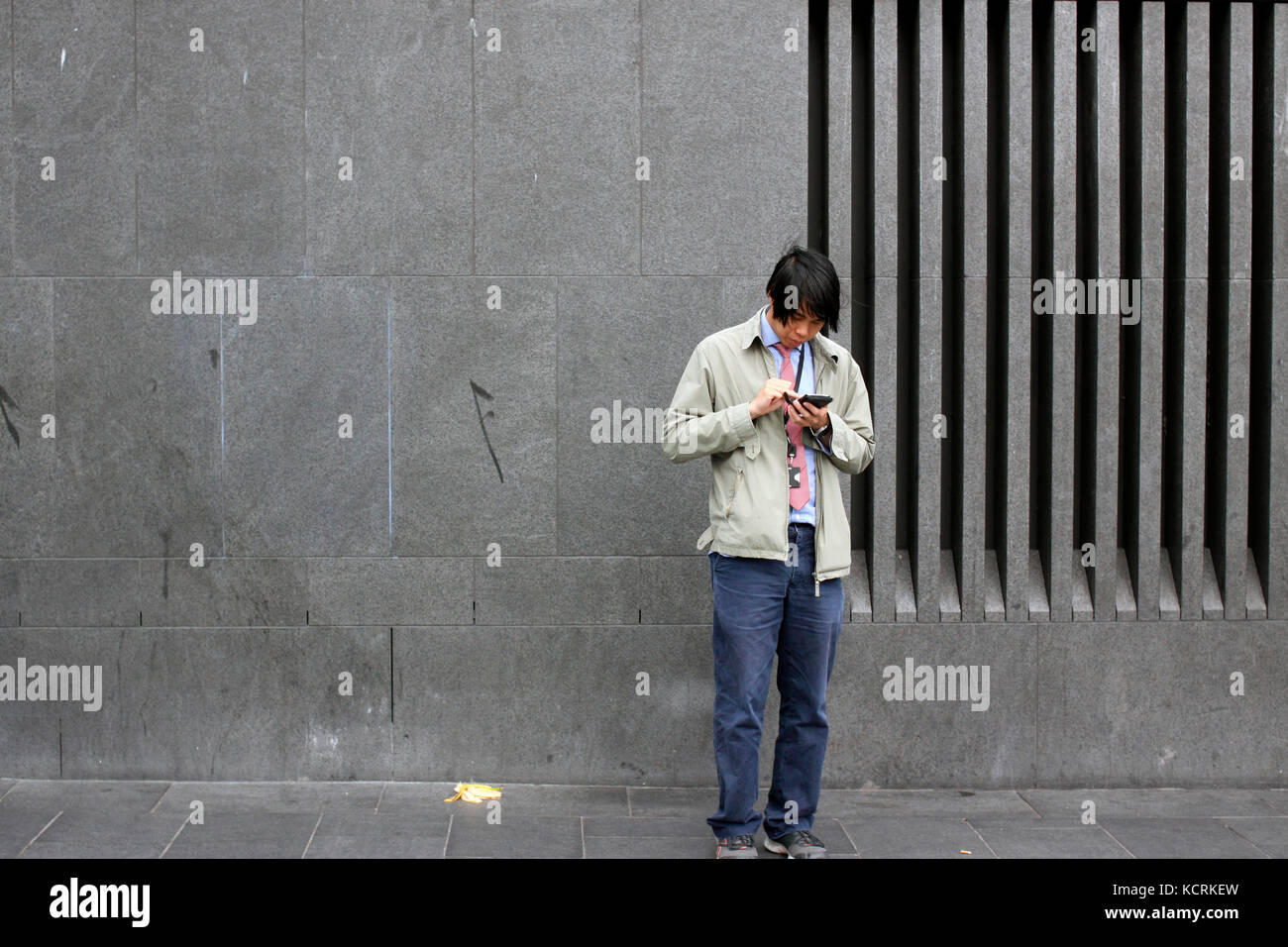 Man using his smart phone on a street in King's Cross, London Stock Photo