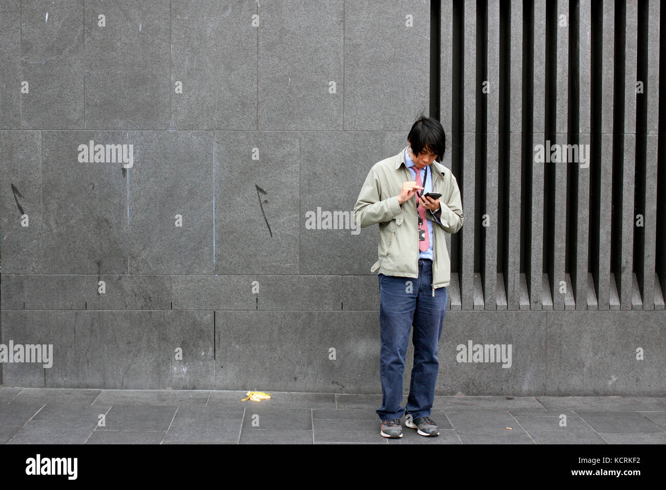 Man using his smart phone on a street in King's Cross, London Stock Photo