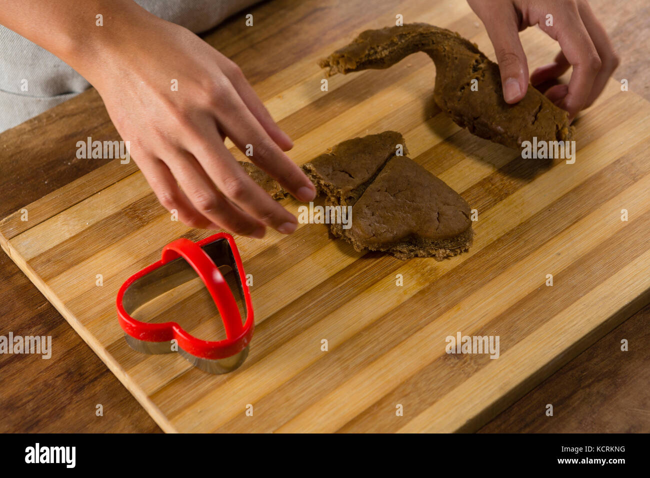 Mid-section of man molding gingerbread dough on wooden board Stock Photo