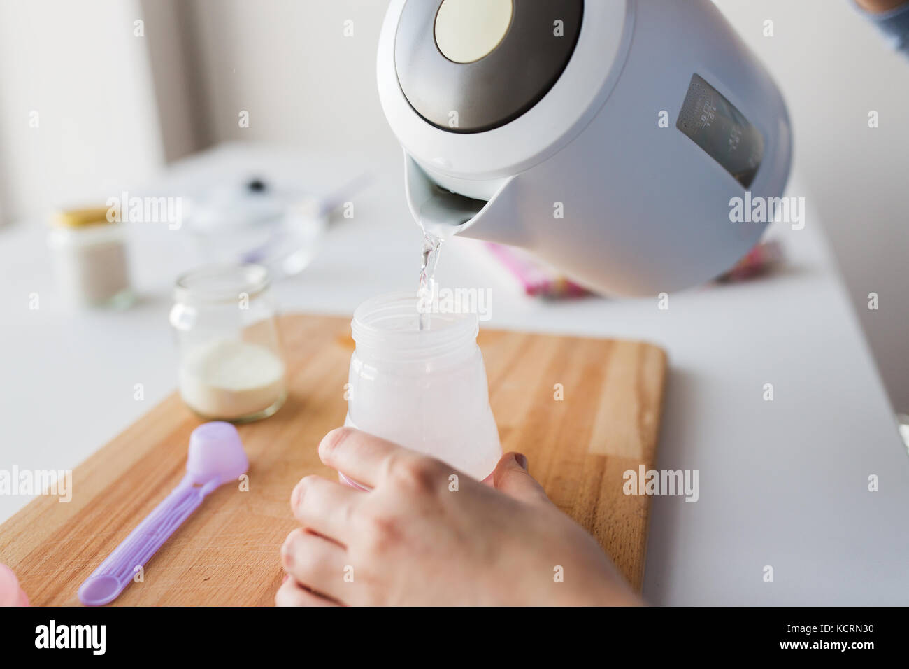 hands with kettle and bottle making baby milk Stock Photo Alamy