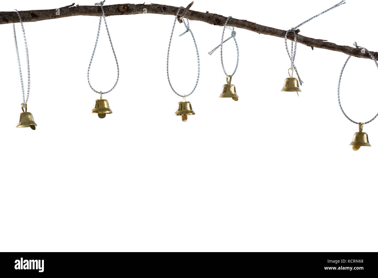 Christmas bells hanging on branch against white background Stock Photo