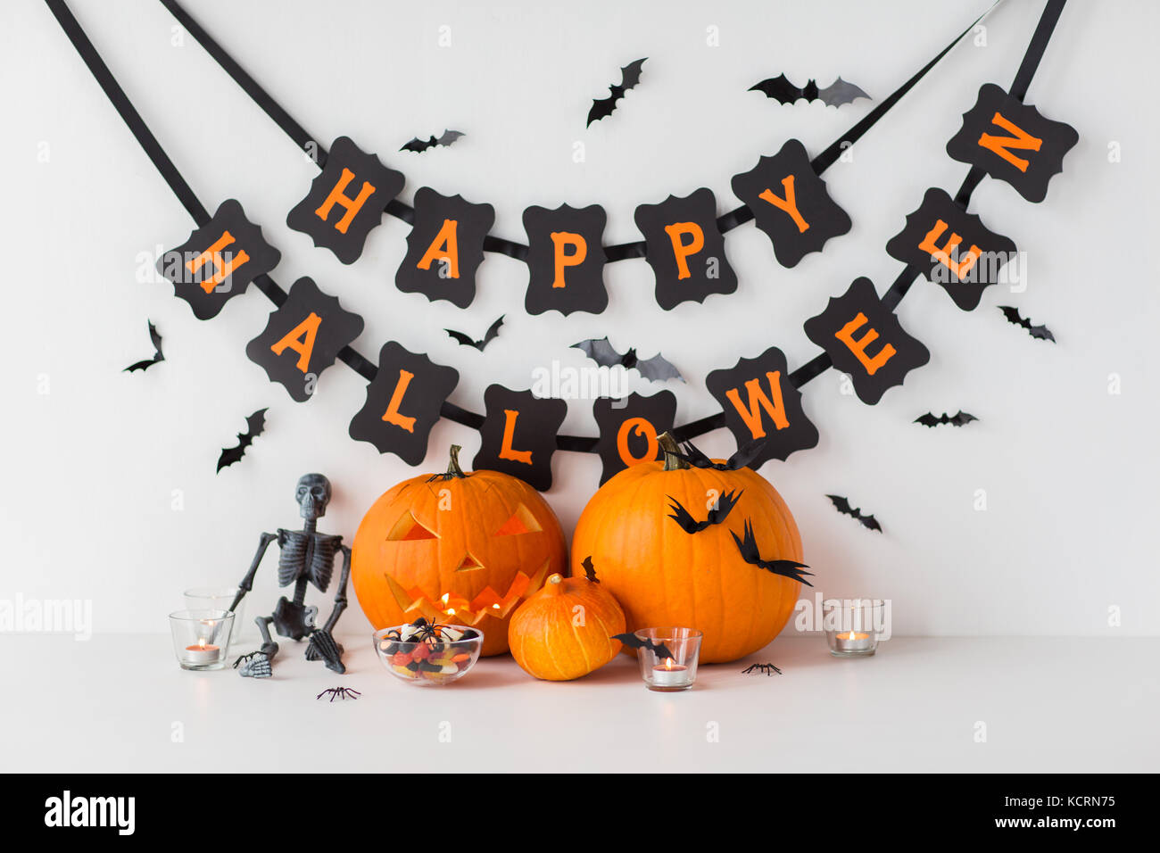 carved pumpkins with candies and halloween garland Stock Photo