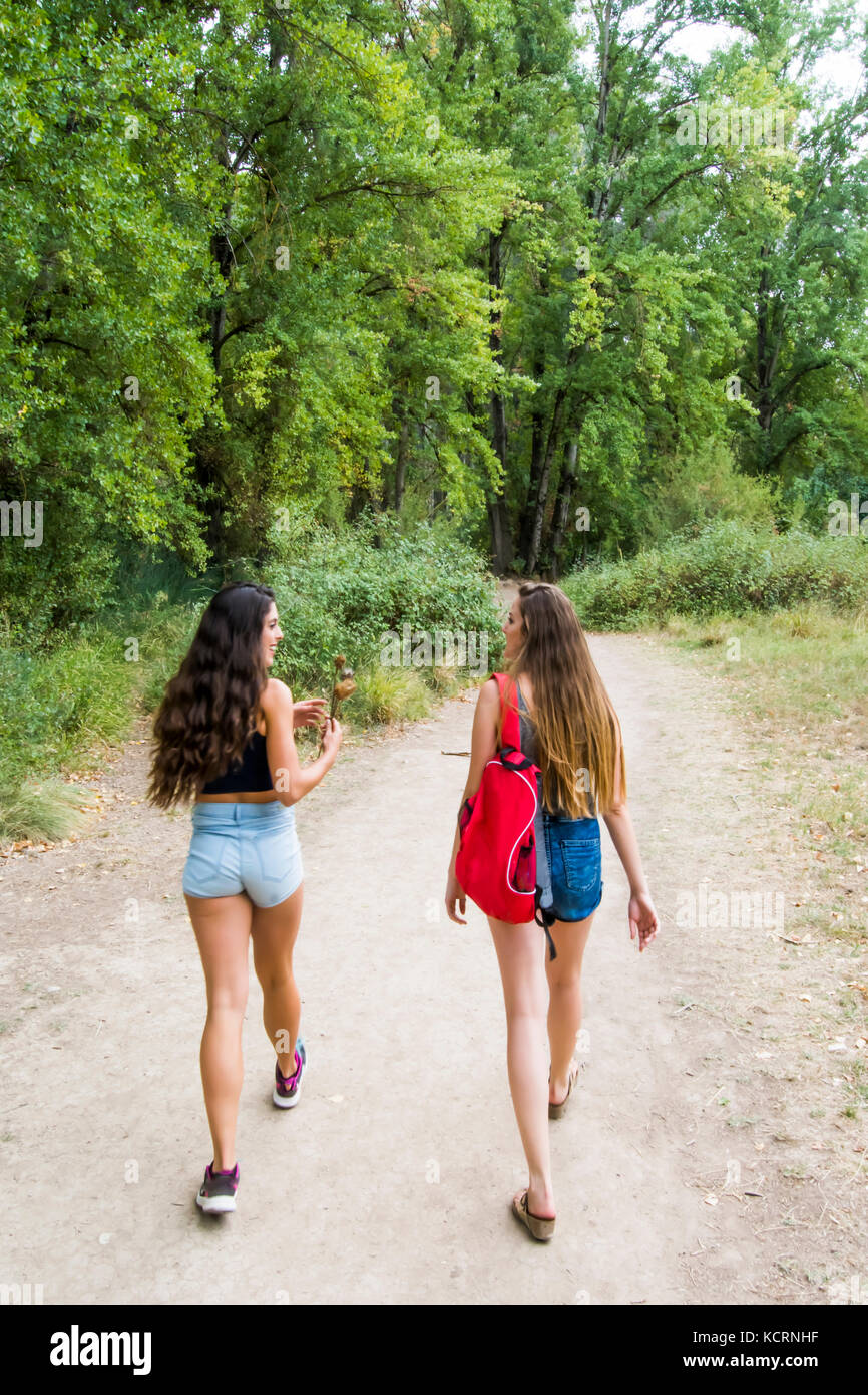Two beautiful women hiking in nature on a mountain road Stock Photo - Alamy