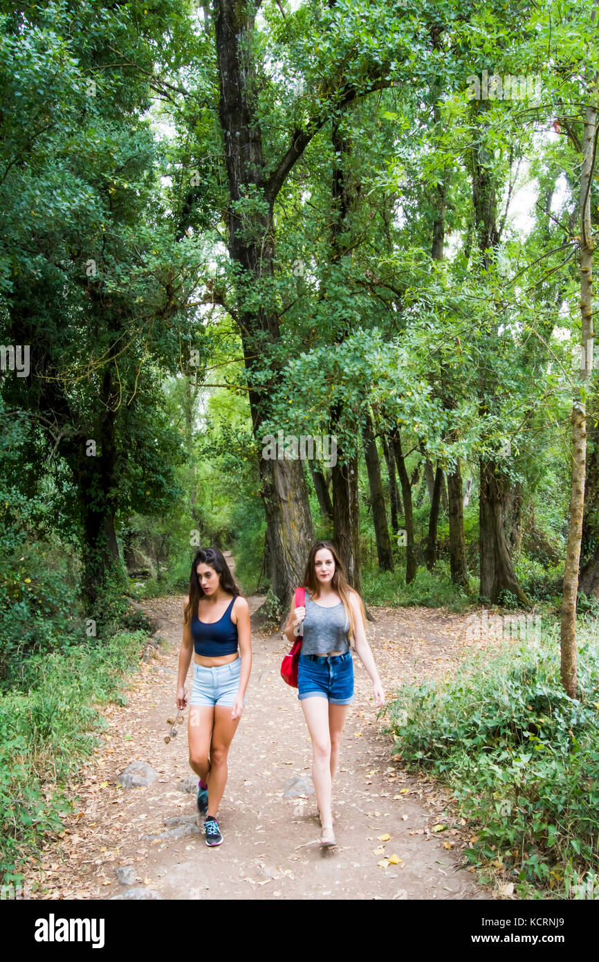 Two beautiful women hiking in nature on a mountain road Stock Photo - Alamy